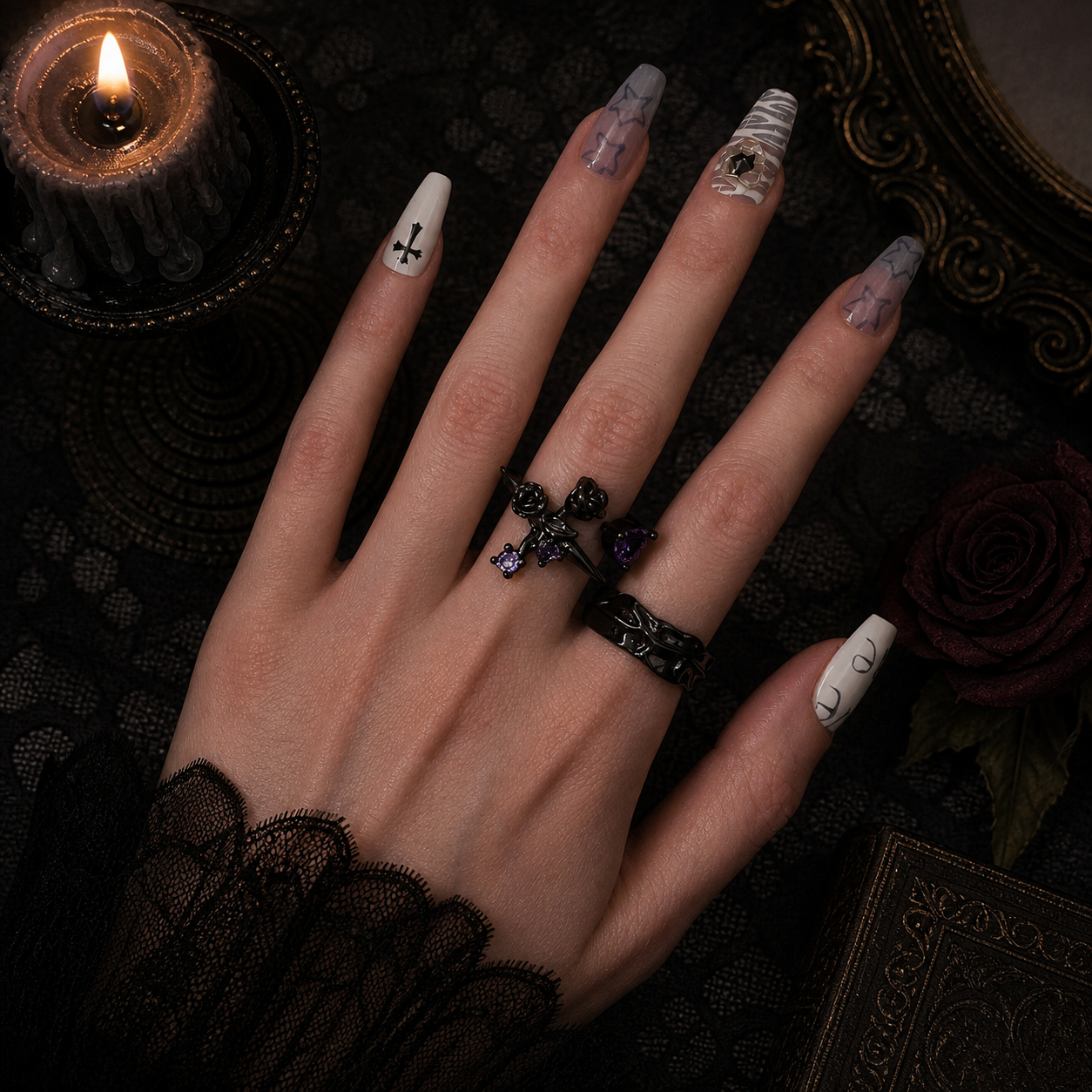 Black rose cross ring with purple stones and black molten band ring worn together on hand, light grey background