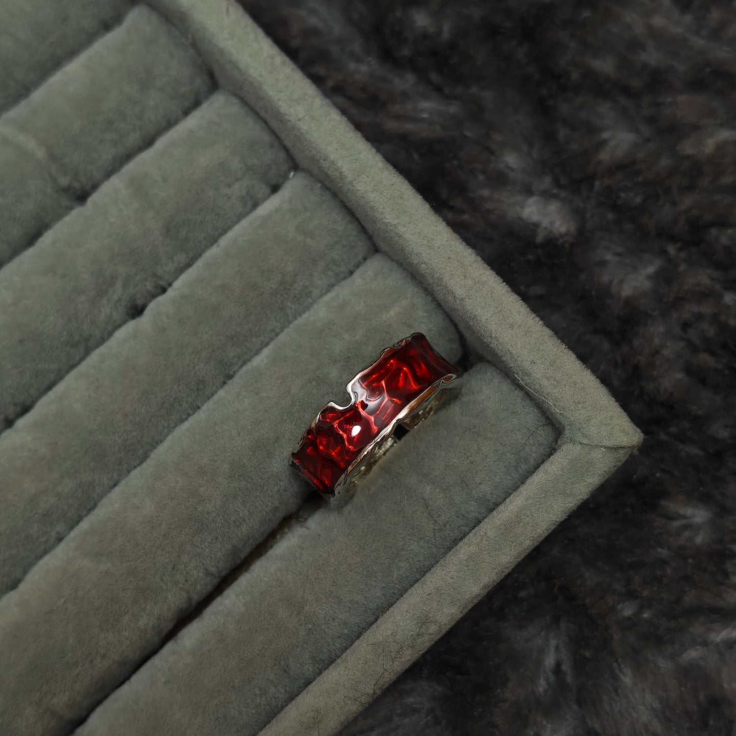 Individual dark romance ring shown alone on grey velvet tray, front detail view