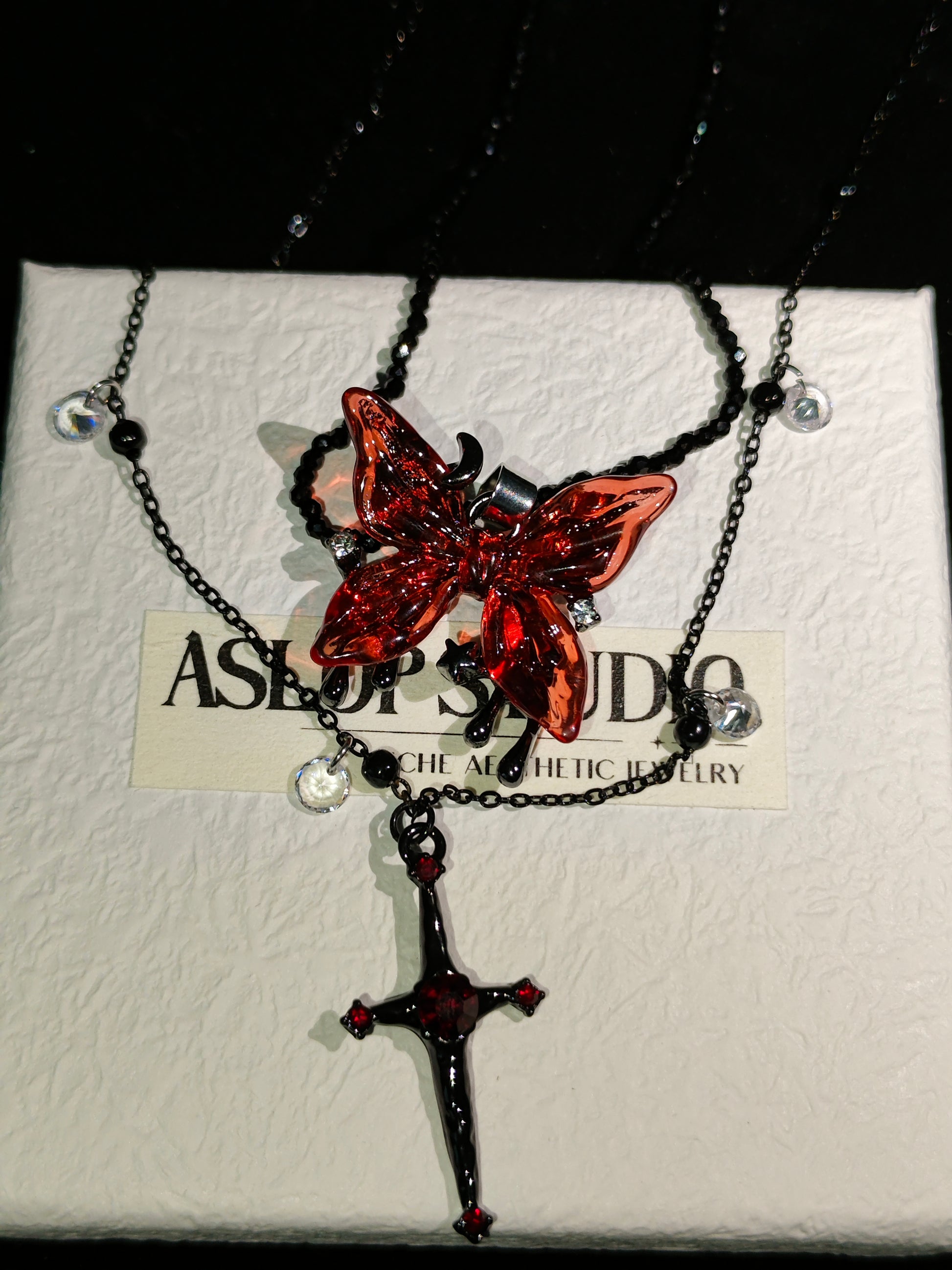 Blood Rose Butterfly & Gothic Cross Necklace in open Aslop Jewelry white gift box, angled view