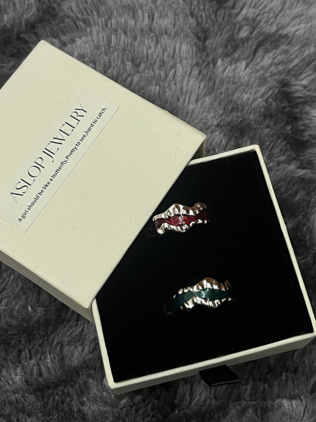 Drip Glaze Wave Ring, Red and Green colorways side by side, close-up on black velvet display