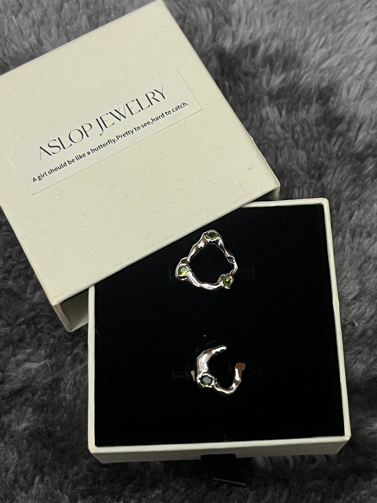Crisscross Emerald Ring in 3-Stone and 1-Stone styles, woven silver bands with green stone accents, in ASLOP TREASURE jewelry box