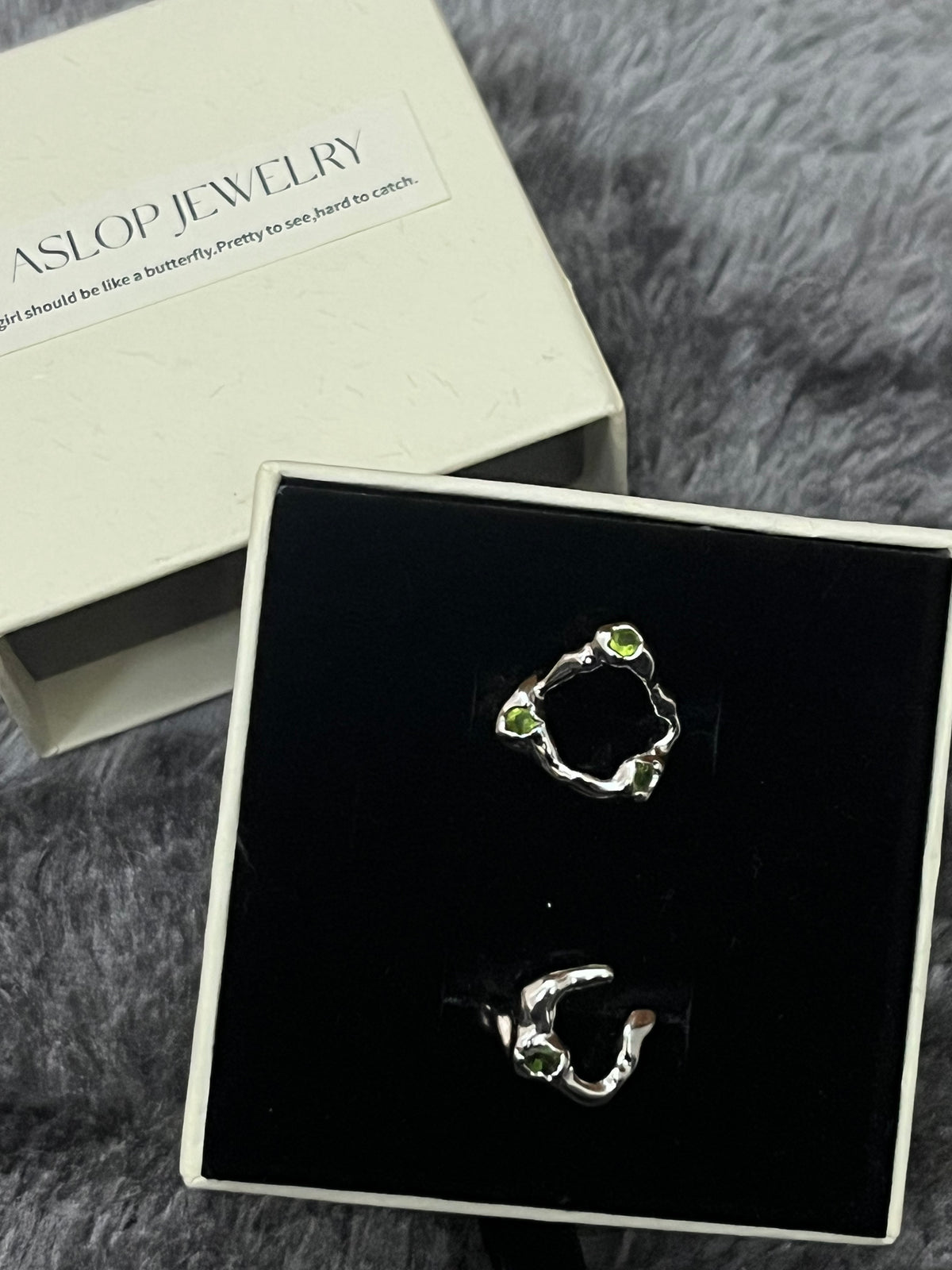 Crisscross Emerald Ring, 3-Stone style close-up showing woven silver band with three green stone accents