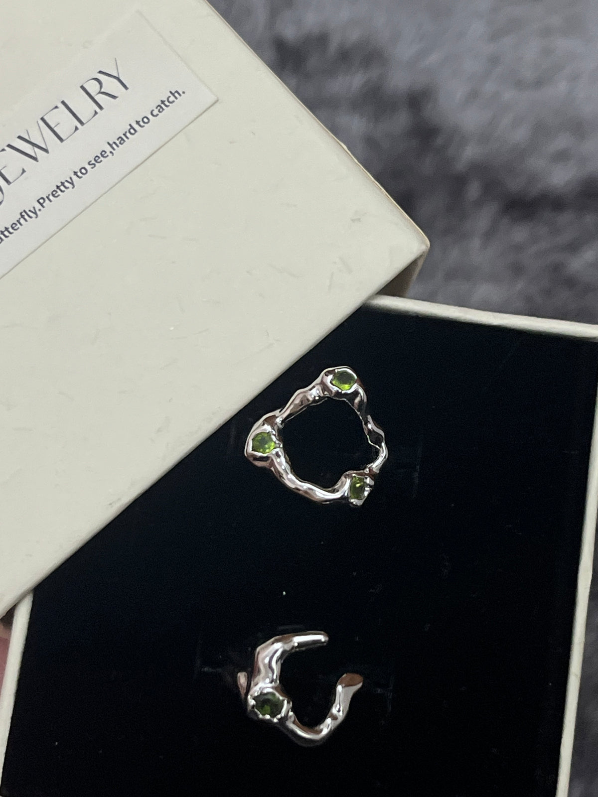 Crisscross Emerald Ring, 1-Stone style close-up showing woven silver band with single green stone accent