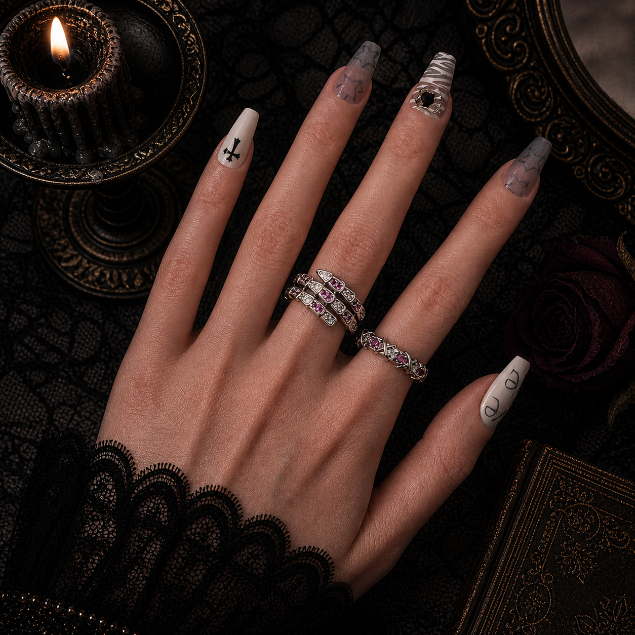 Silver serpent coil ring and pavé band with pink and clear stones worn stacked on hand, dark gothic candle background