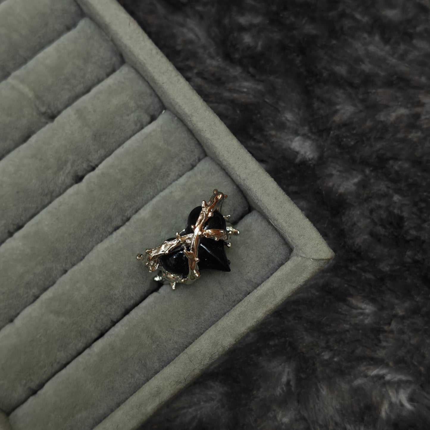 Standalone soft goth charm ring on grey velvet tray, top-down detail photo