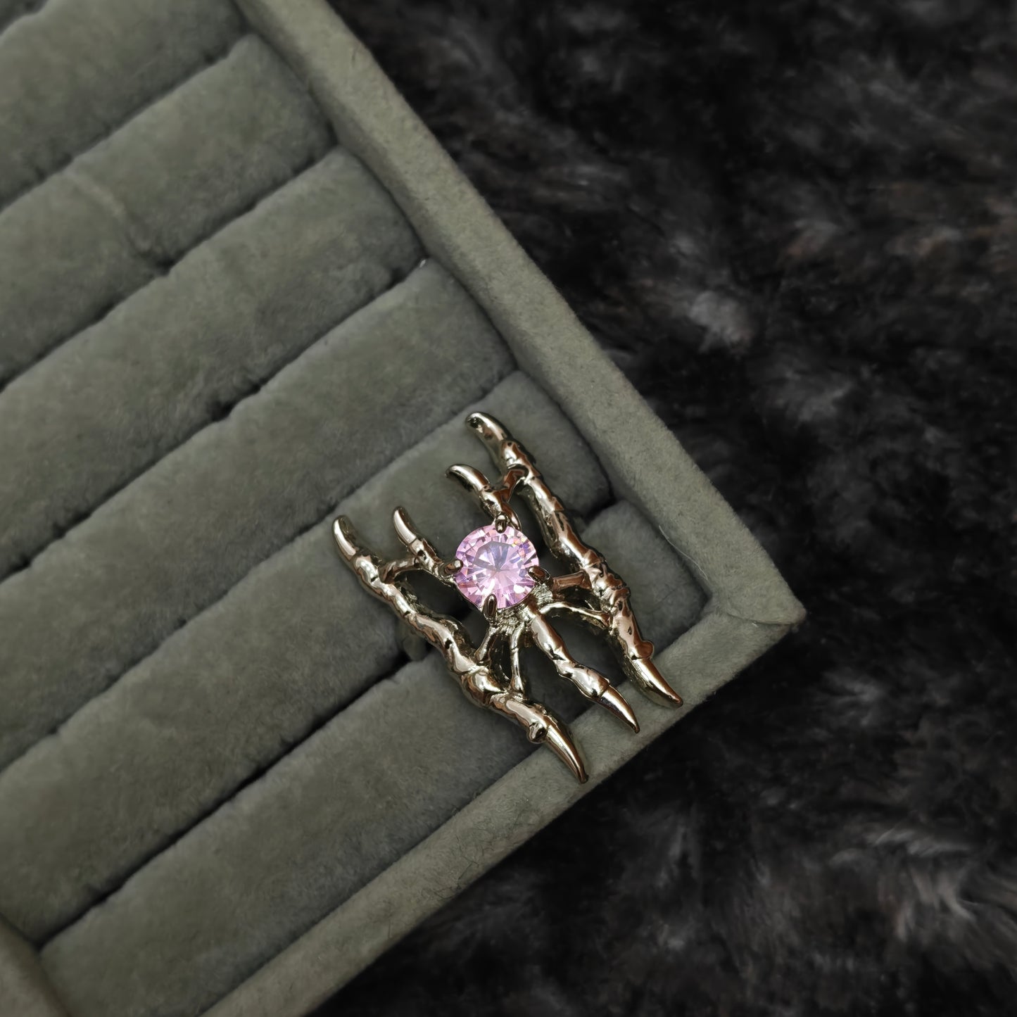 Single soft goth ring displayed individually on grey velvet tray, detail shot