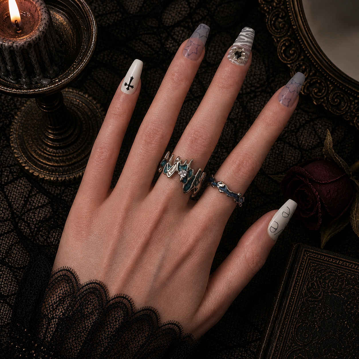 Teal enamel molten wide band ring with clear stone and teal wavy slim band worn together on hand, dark gothic candle background