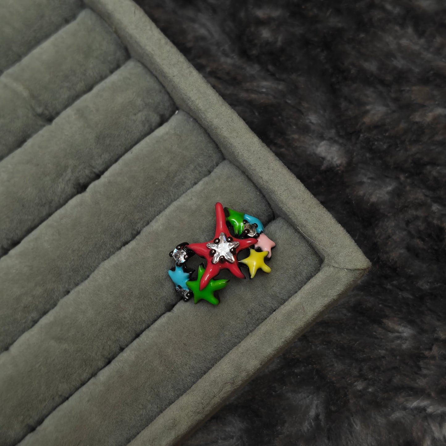 Single y2k colorful fun ring displayed individually on grey velvet display, close-up angle
