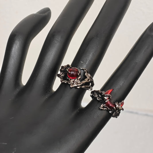 Two gothic gunmetal rings with red detail on hand