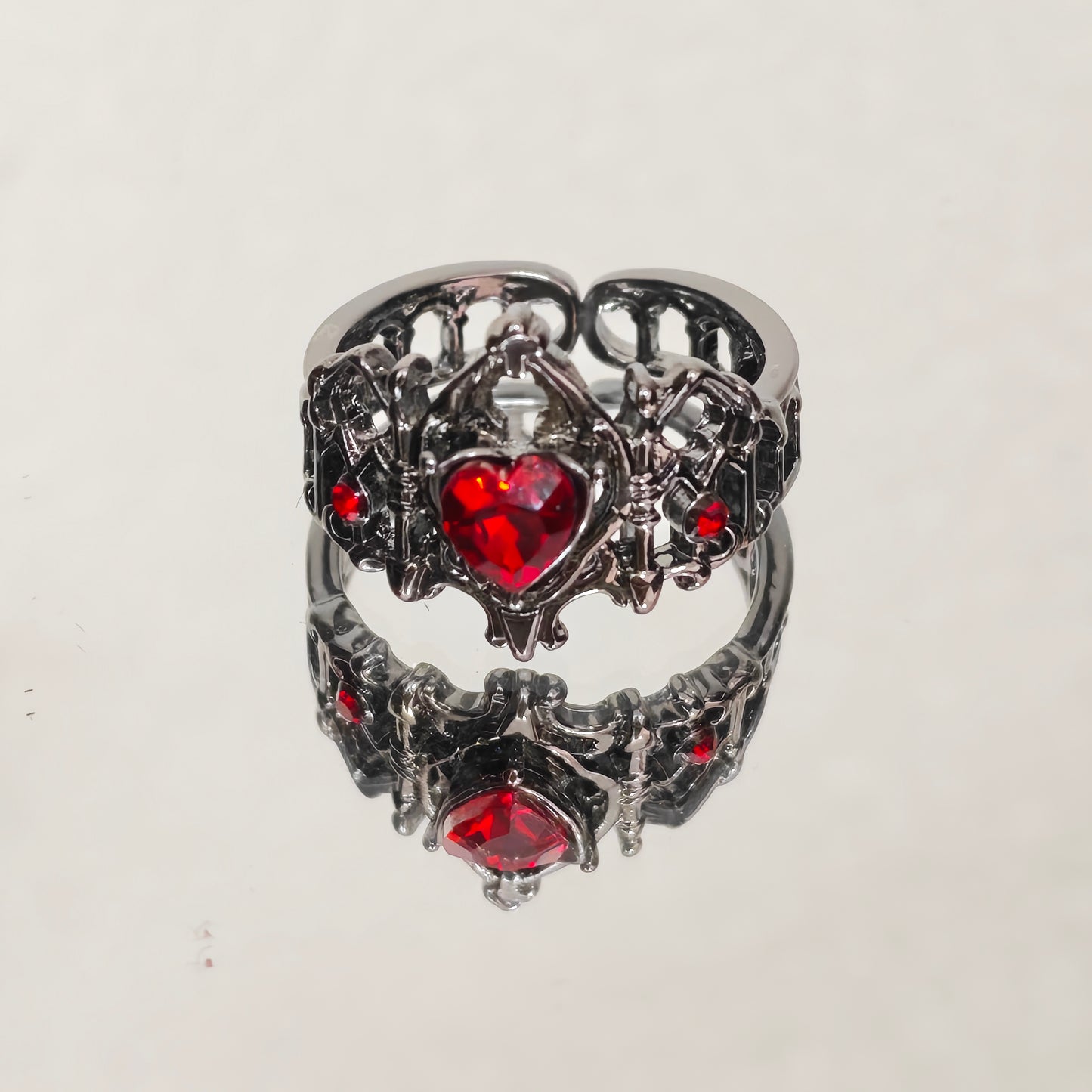 Adjustable gothic heart crown ring in gunmetal with red stone