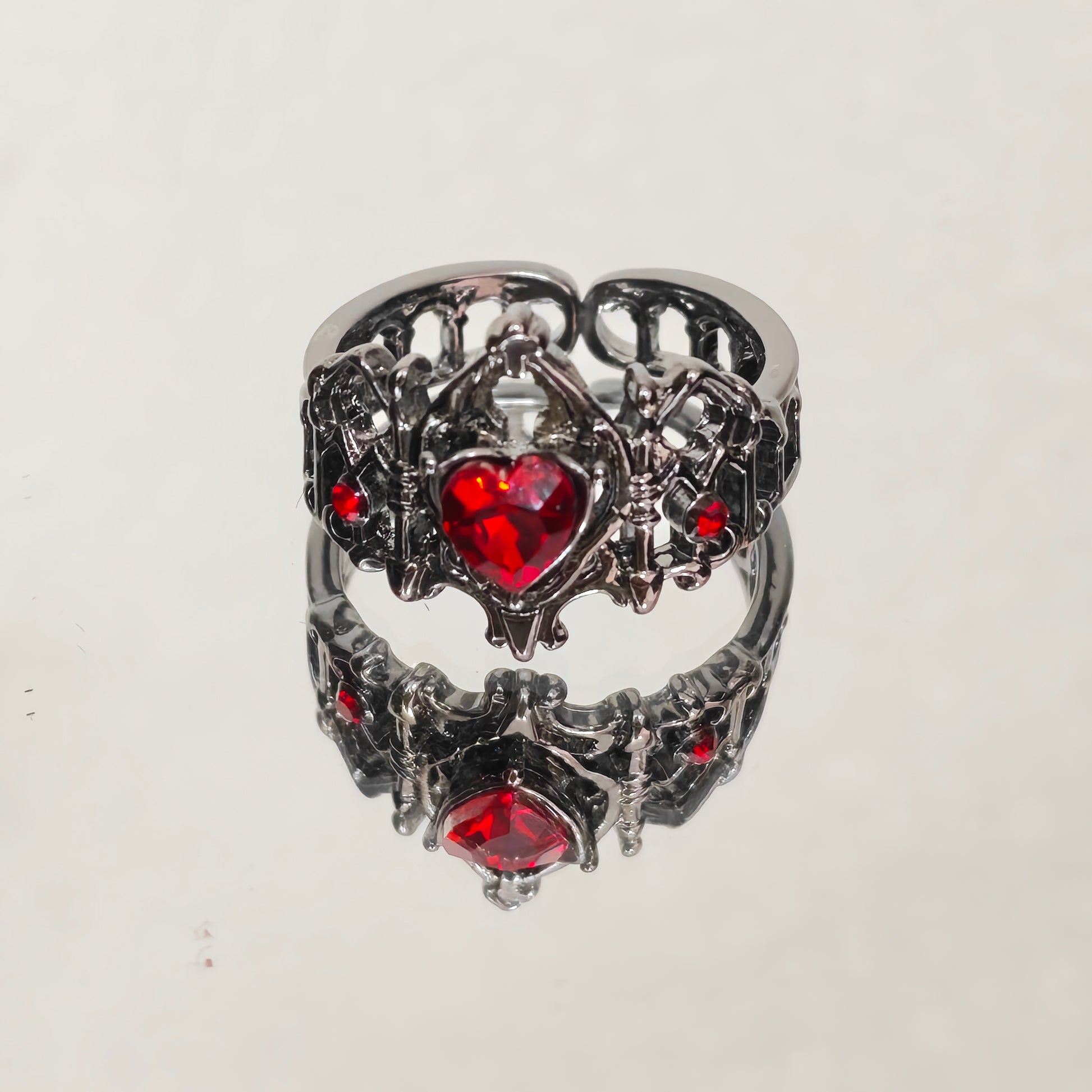 Adjustable gothic heart crown ring in gunmetal with red stone