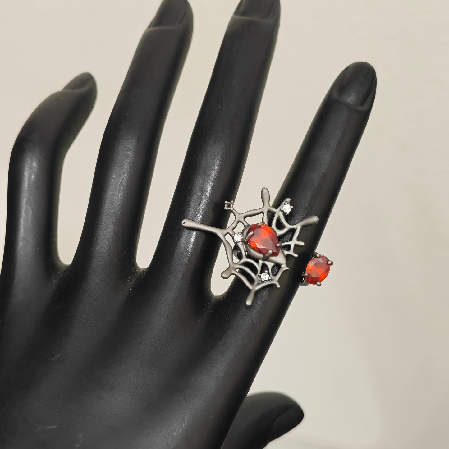 Gunmetal spider web ring red stone close up