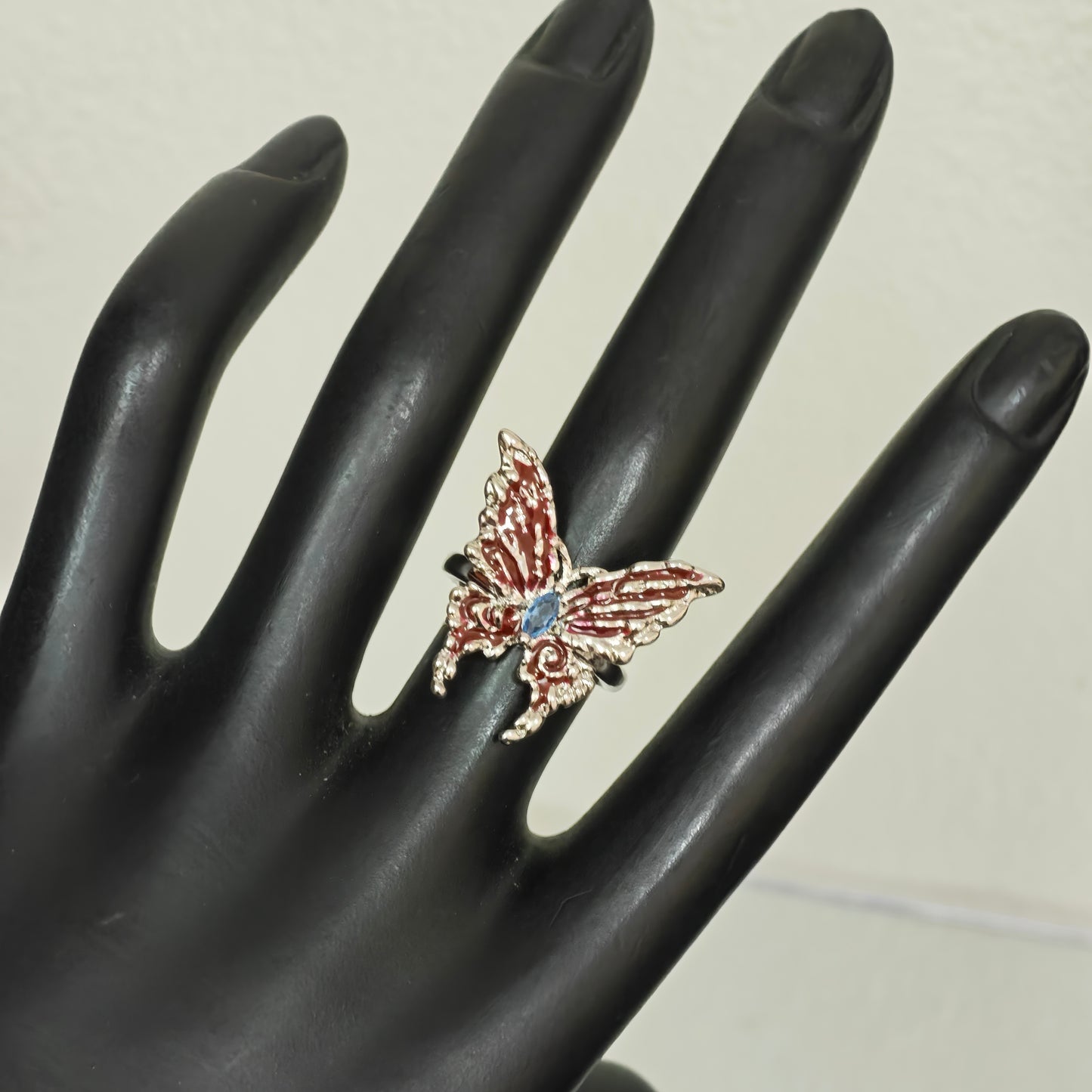 Red enamel butterfly ring blue centre stone close up