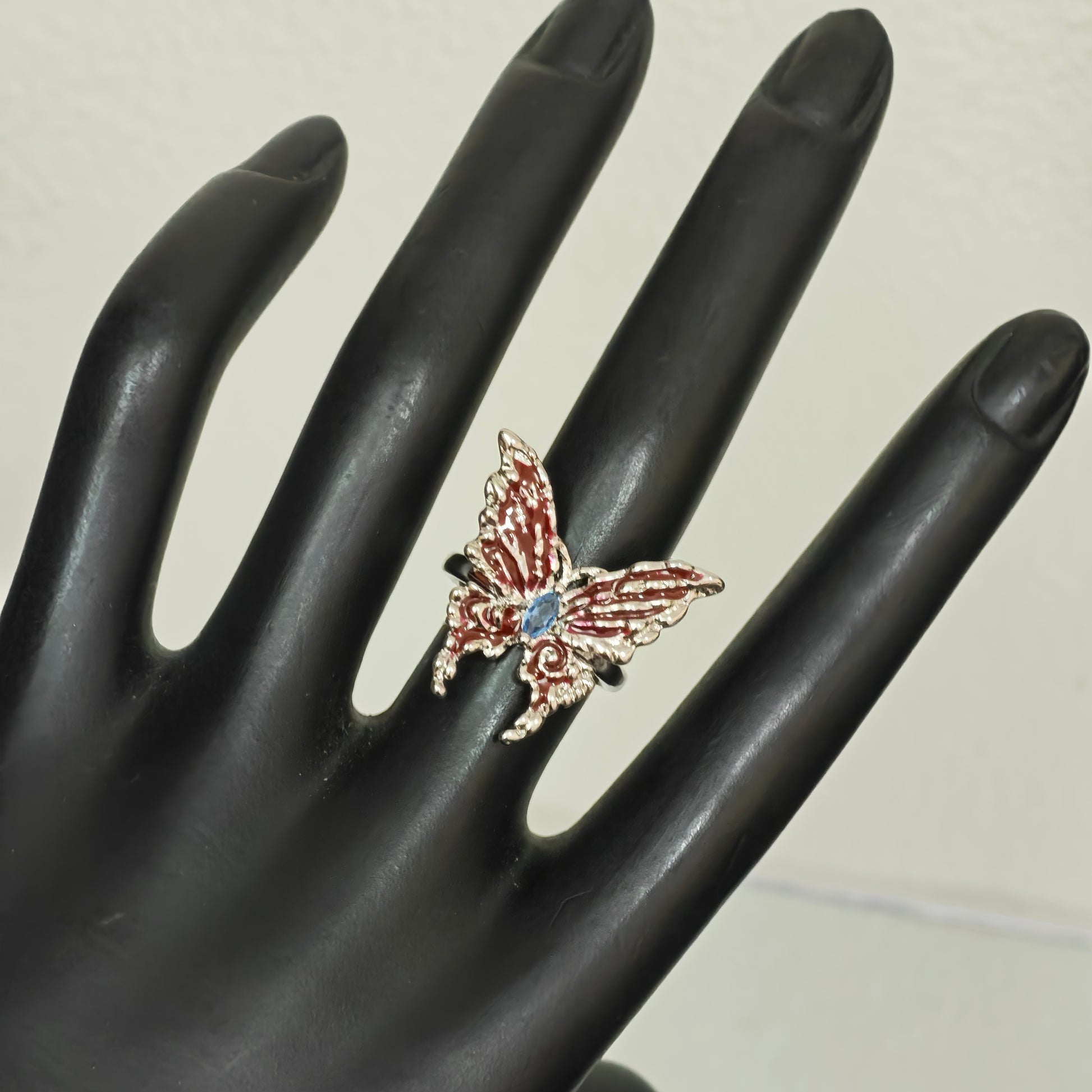 Red enamel butterfly ring blue centre stone close up