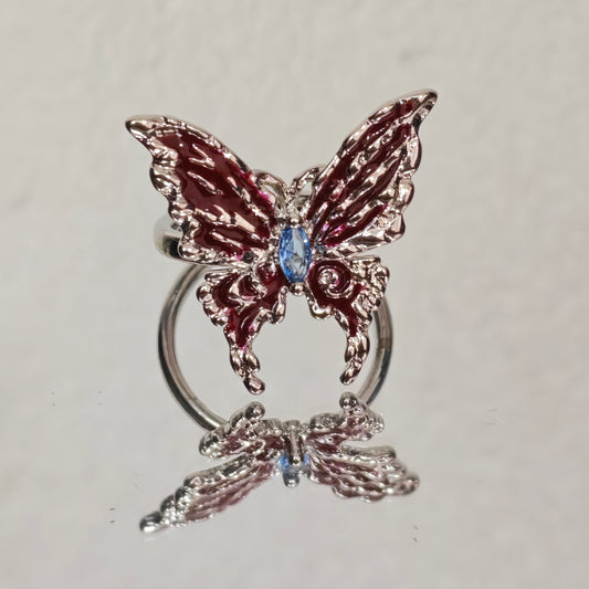 Adjustable silver butterfly ring with red enamel wings and blue stone