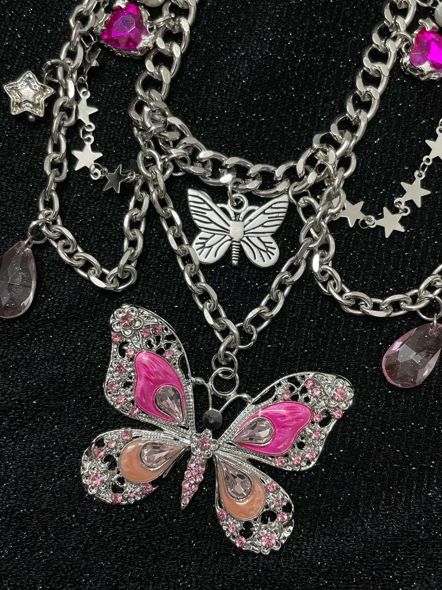 Pink Butterfly Charm Necklace in open black velvet jewelry box, angled view