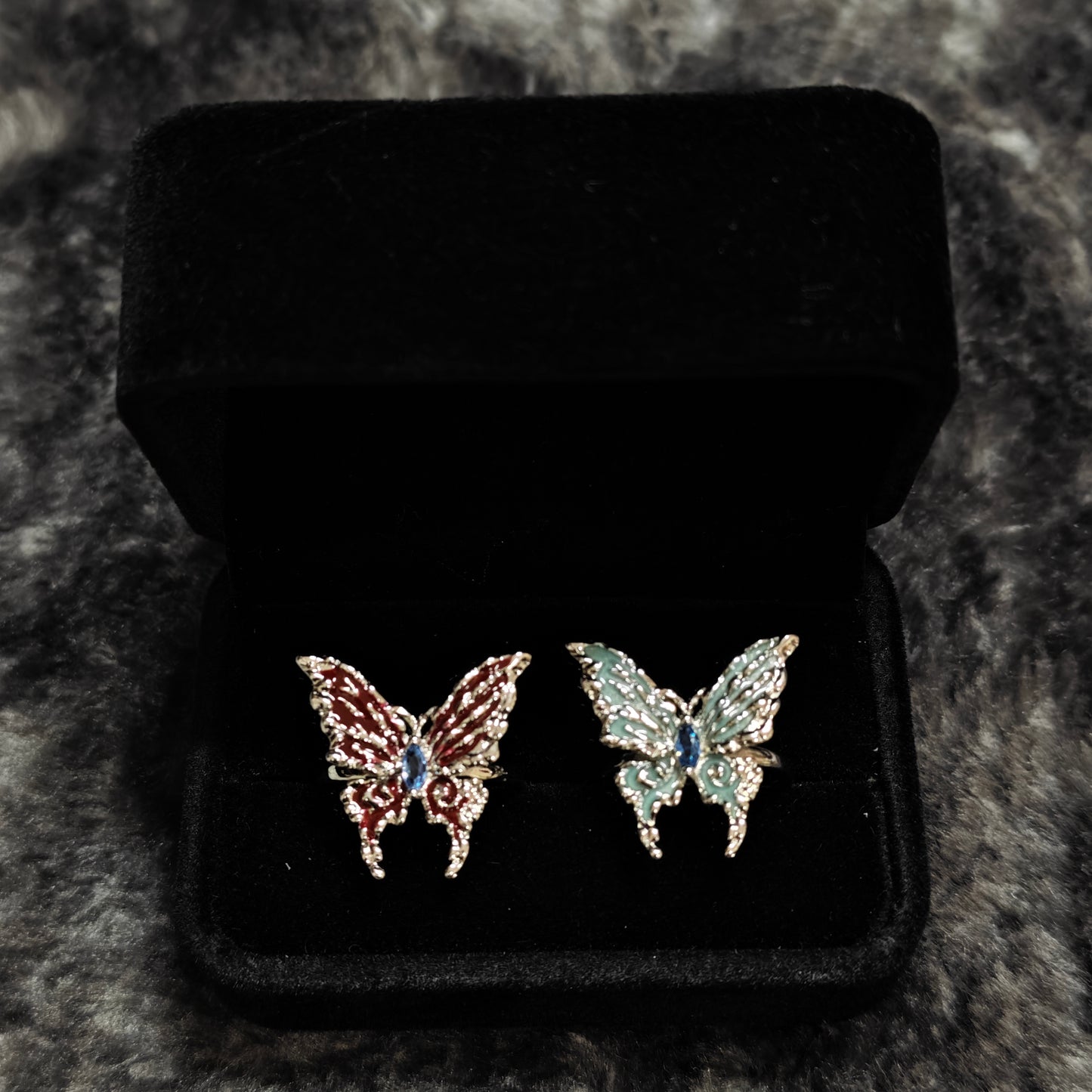Red Enamel Butterfly Ring on black mannequin hand, front view close-up
