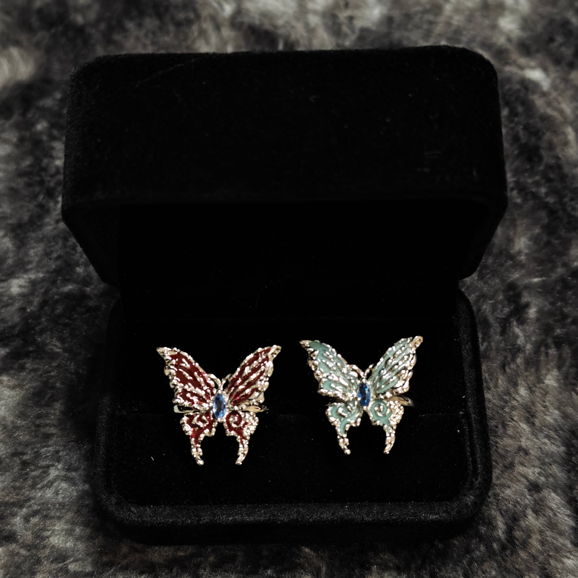 Red Enamel Butterfly Ring on black mannequin hand, front view close-up