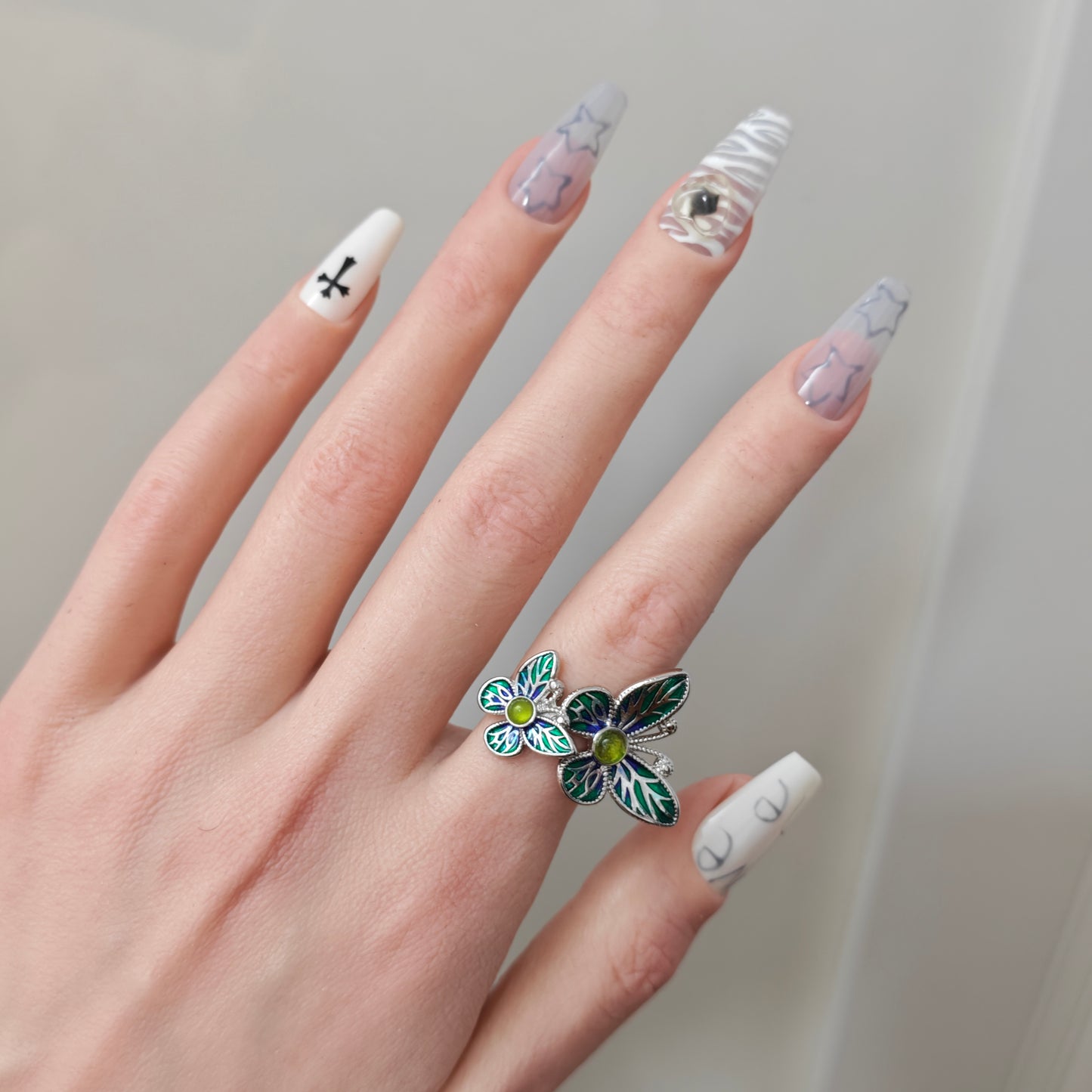 Double Butterfly Enamel Ring on black mannequin hand, front view close-up