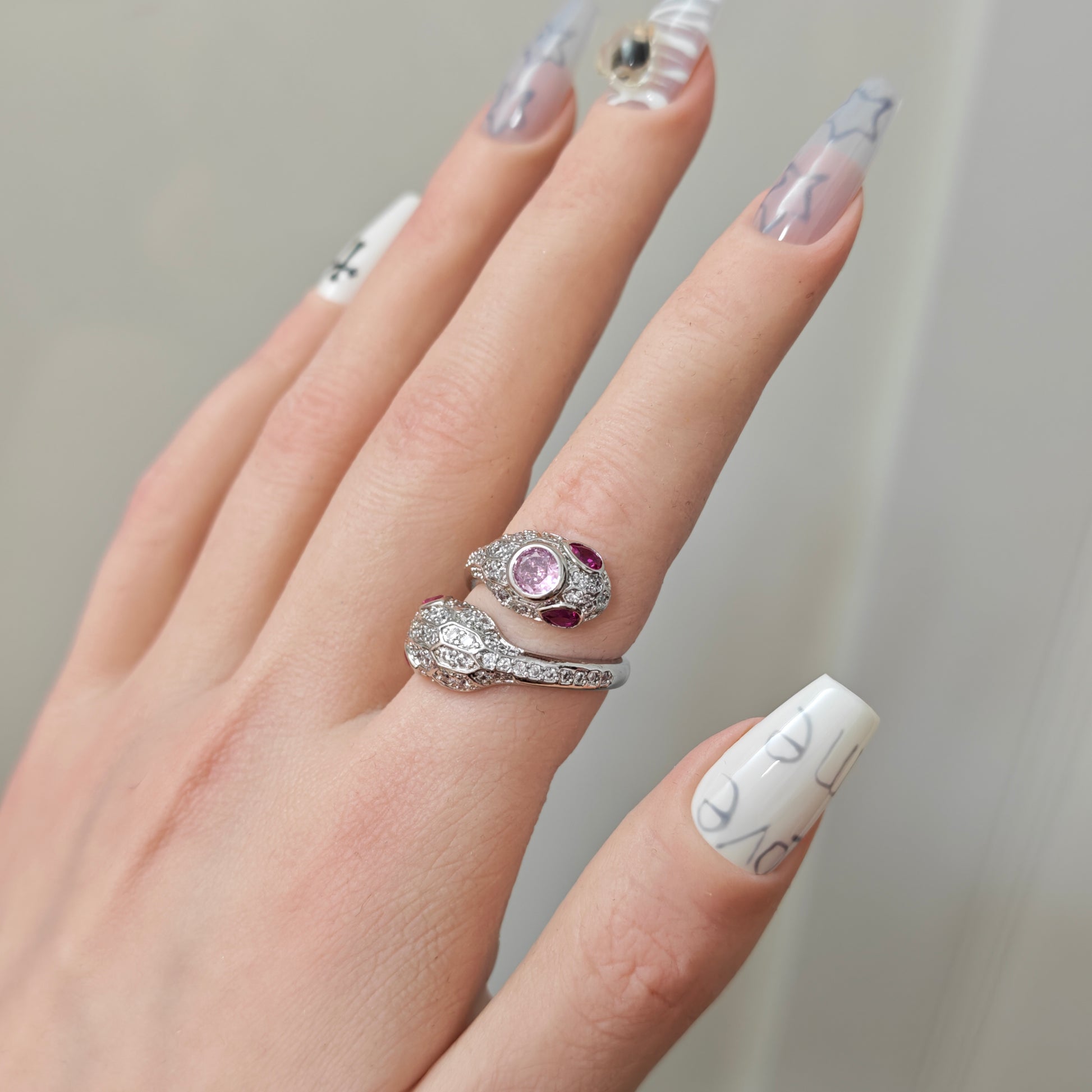 Pink Snake Ring in open black velvet jewelry box, angled view