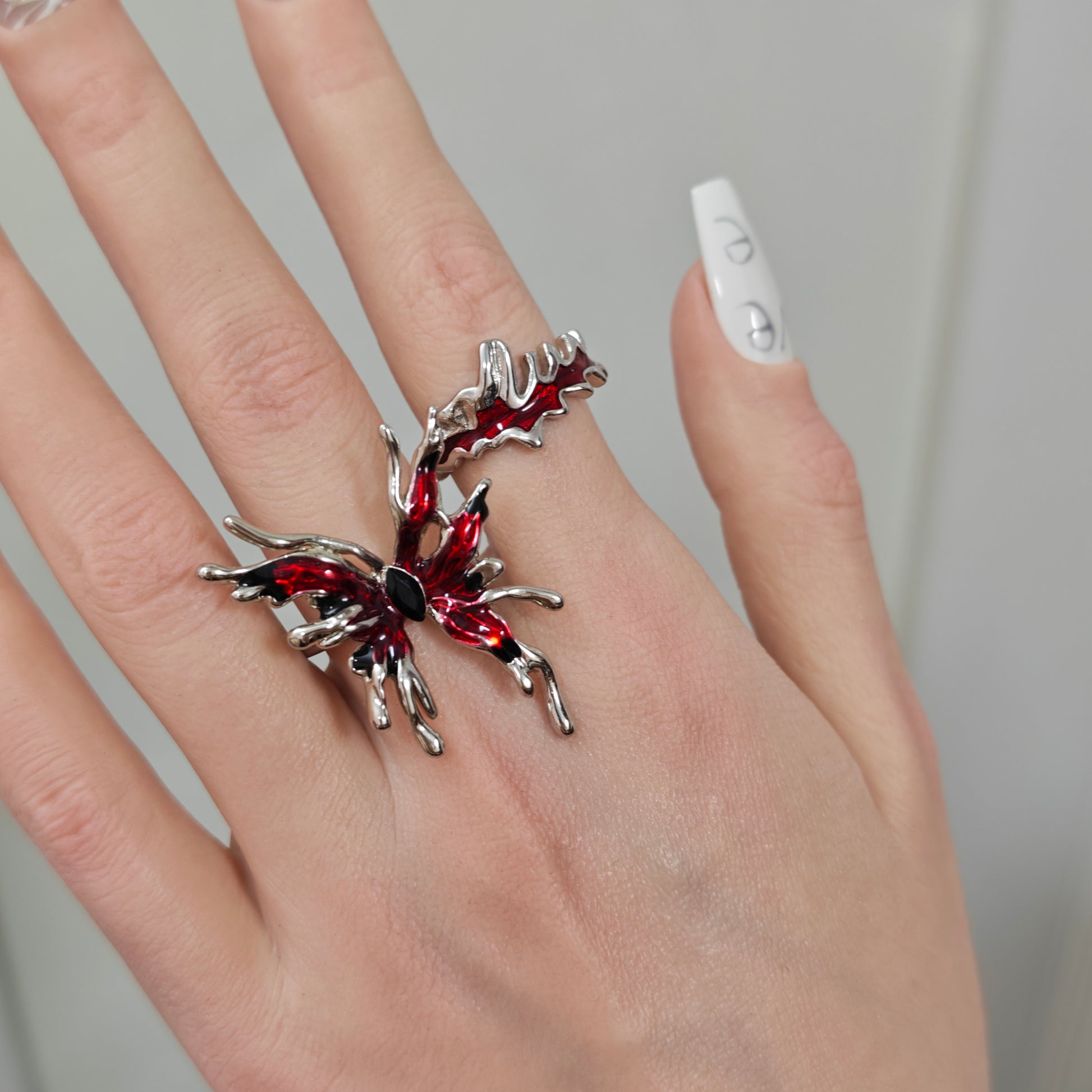 Red Butterfly Ring Set on black mannequin hand, front view close-up
