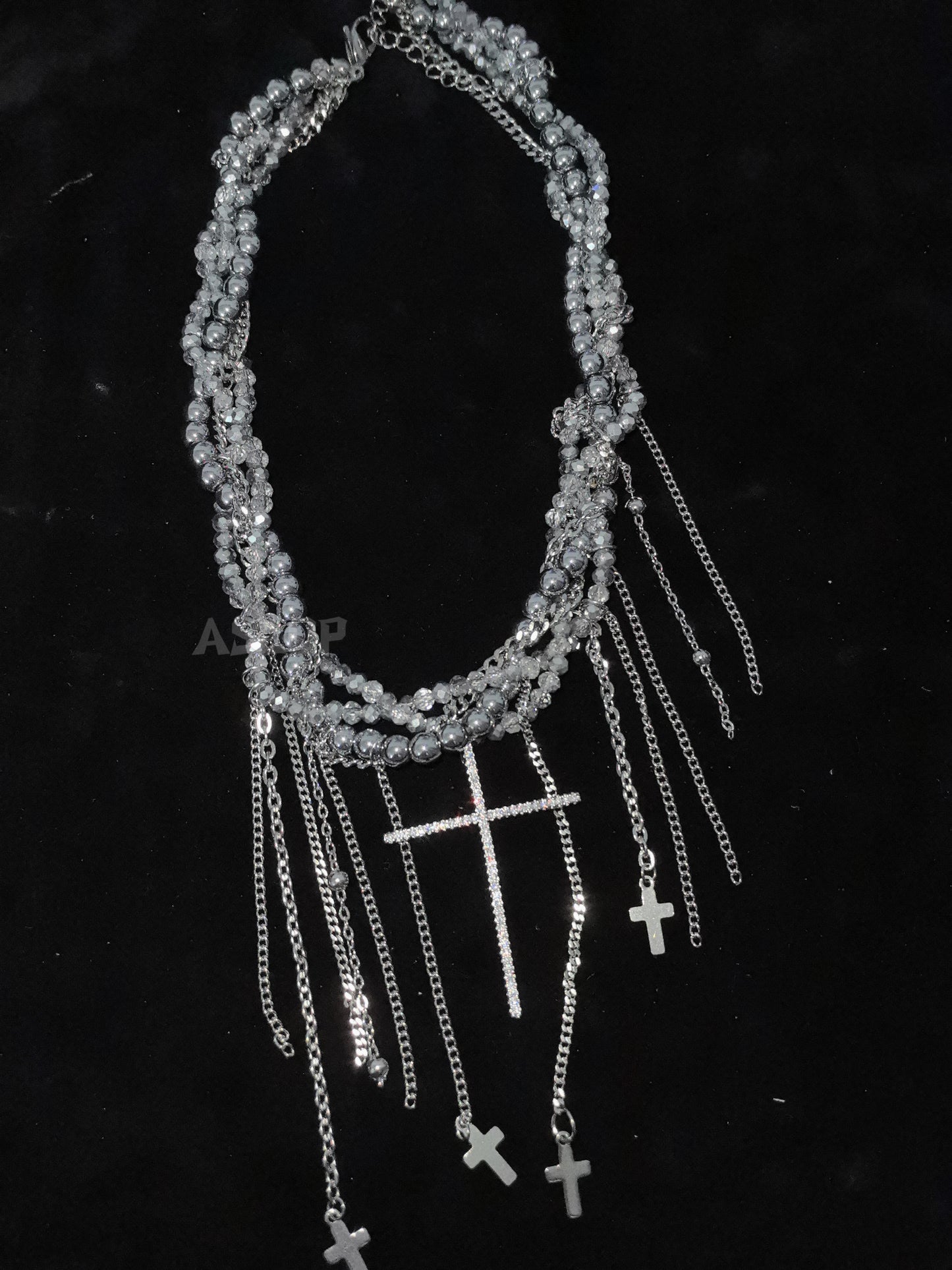 Crystal Cross Tassel Necklace in open black velvet jewelry box, overhead flat lay
