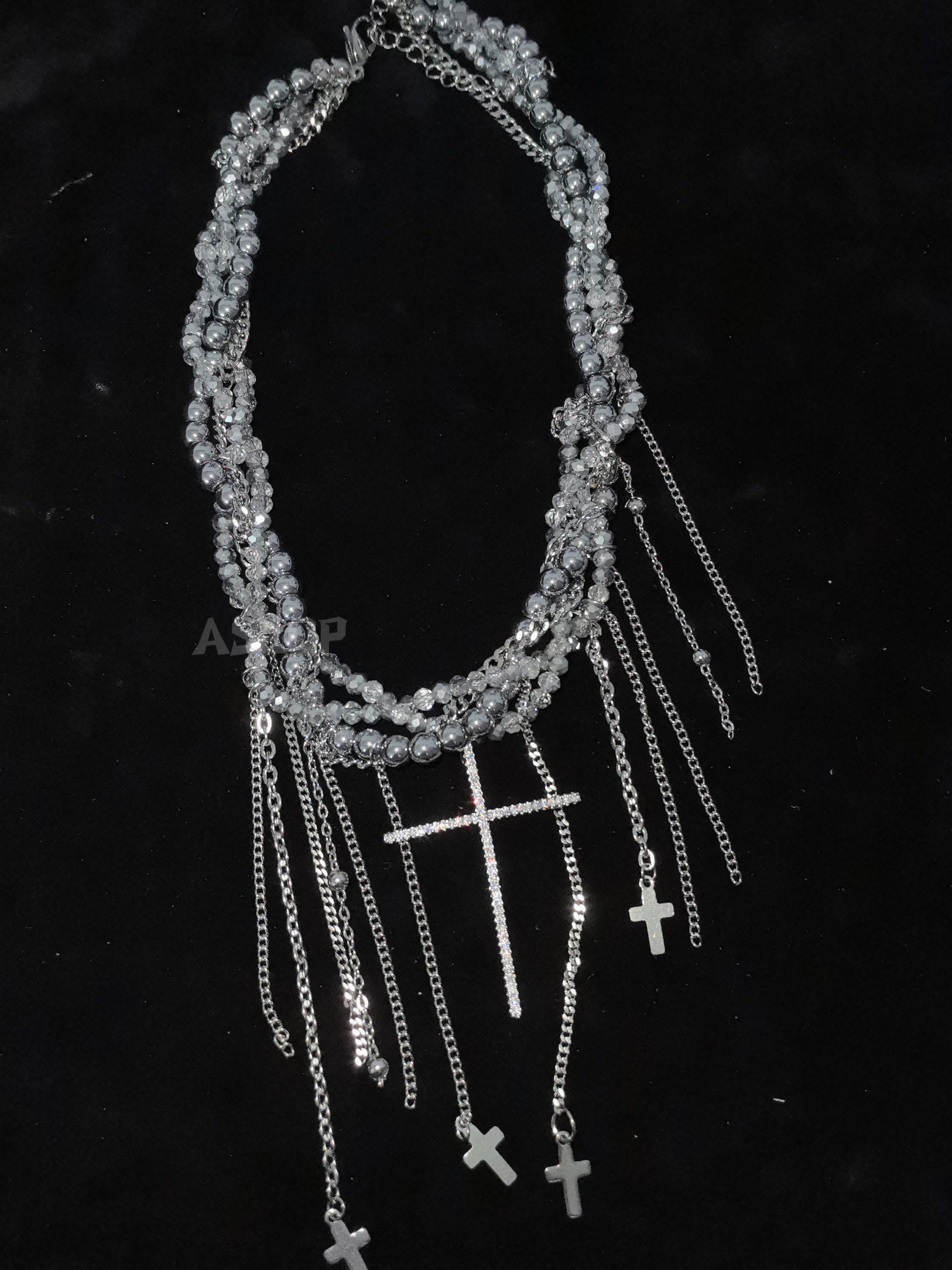 Crystal Cross Tassel Necklace in open black velvet jewelry box, overhead flat lay