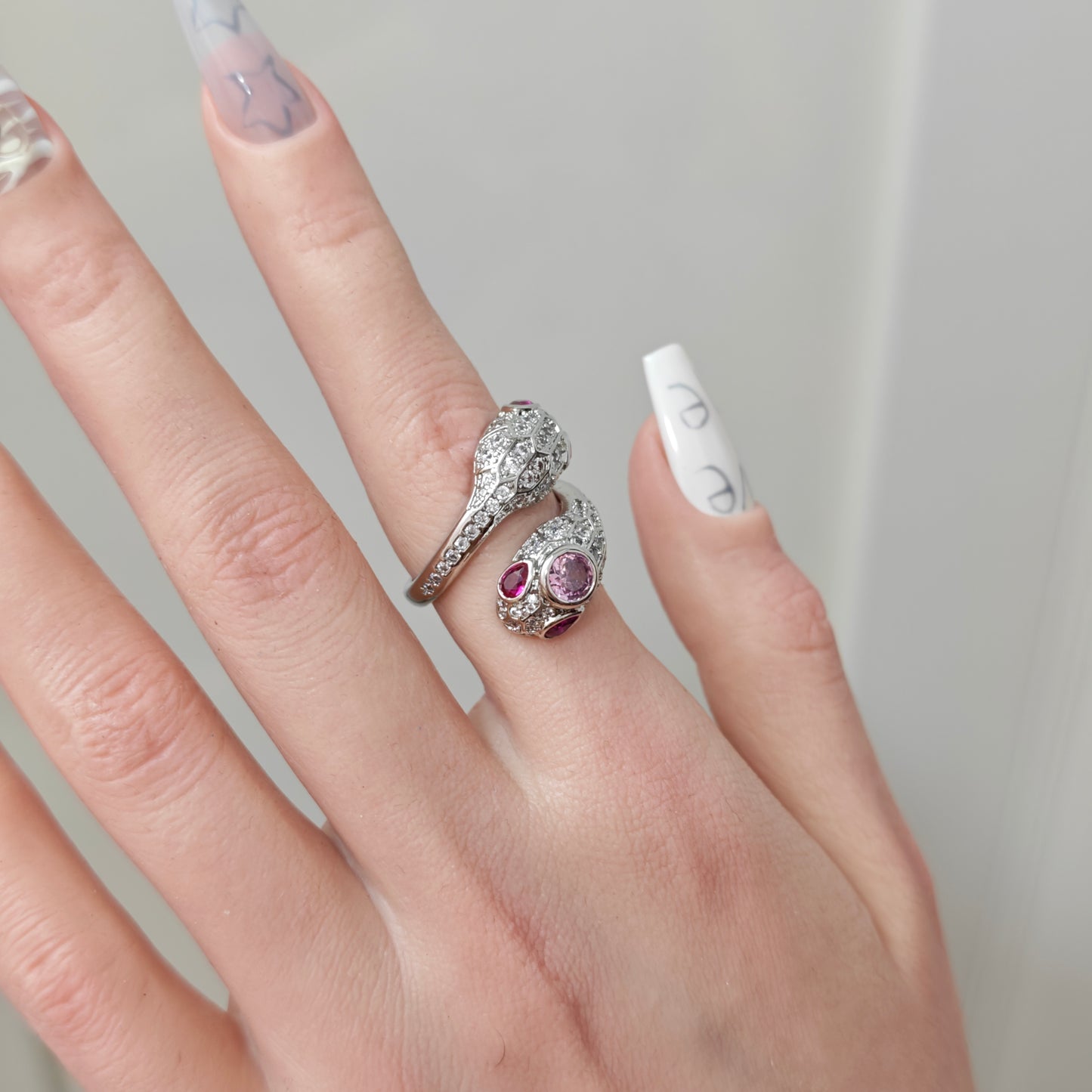 Pink Snake Ring on black mannequin hand, front view close-up