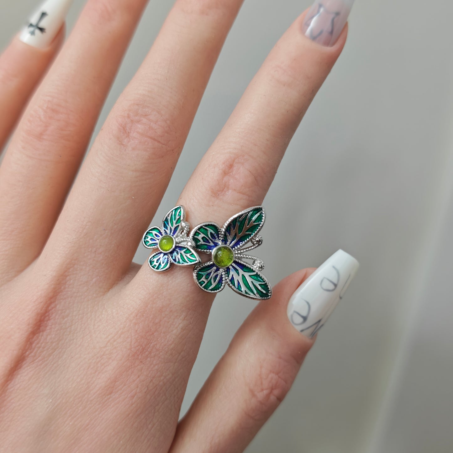 Double Butterfly Enamel Ring in open black velvet jewelry box, overhead flat lay