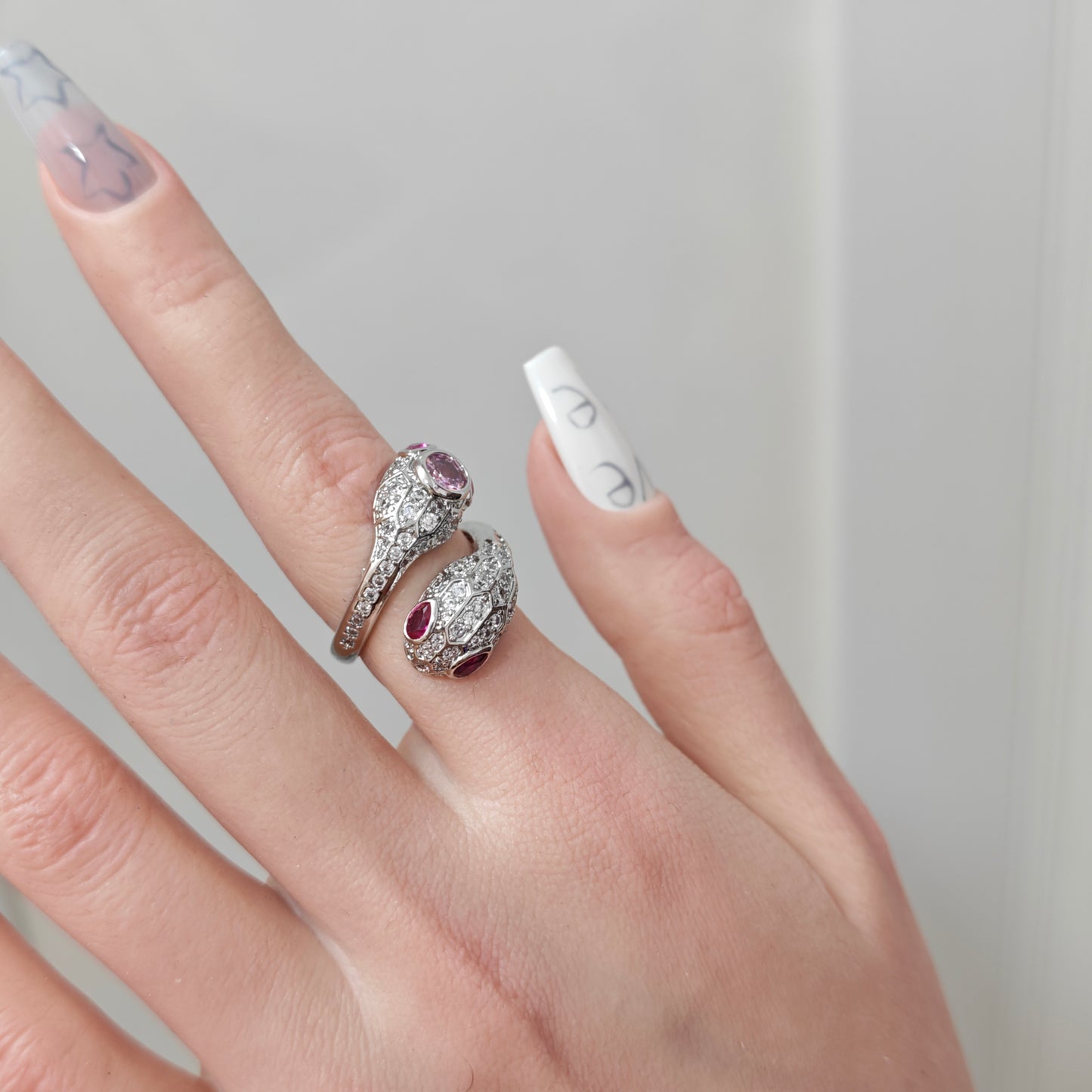 Pink Snake Ring in open black velvet jewelry box, overhead flat lay