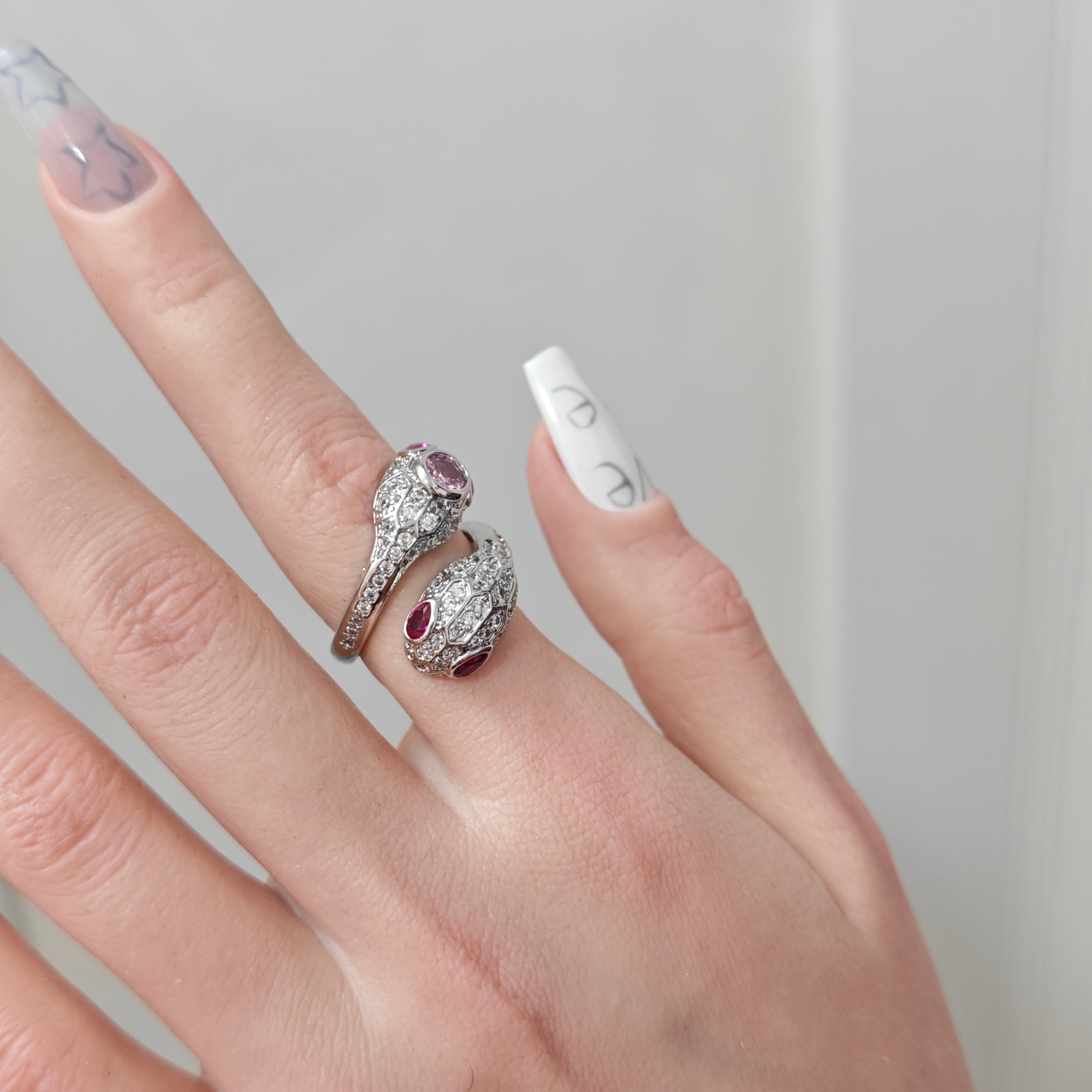 Pink Snake Ring in open black velvet jewelry box, overhead flat lay