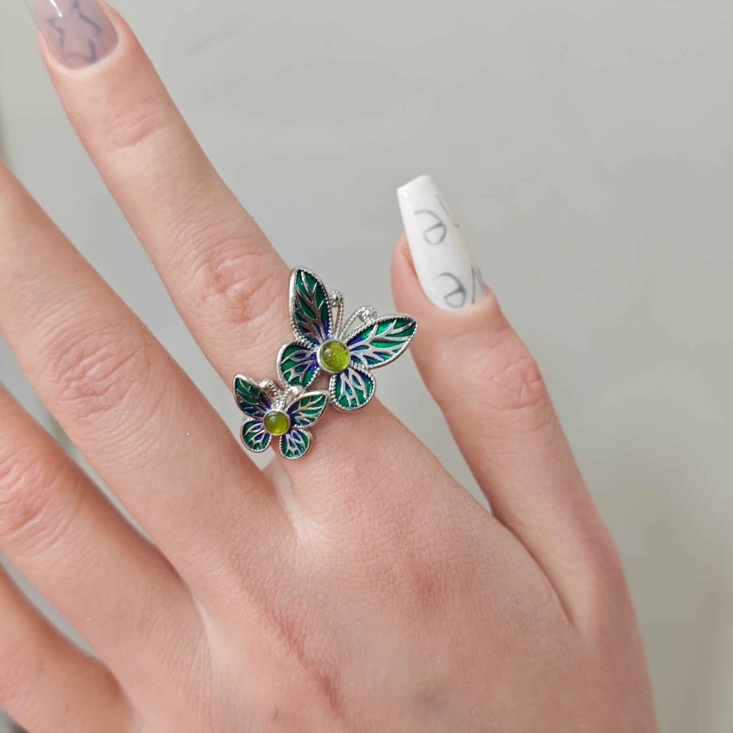 Double Butterfly Enamel Ring in open black velvet jewelry box, angled view