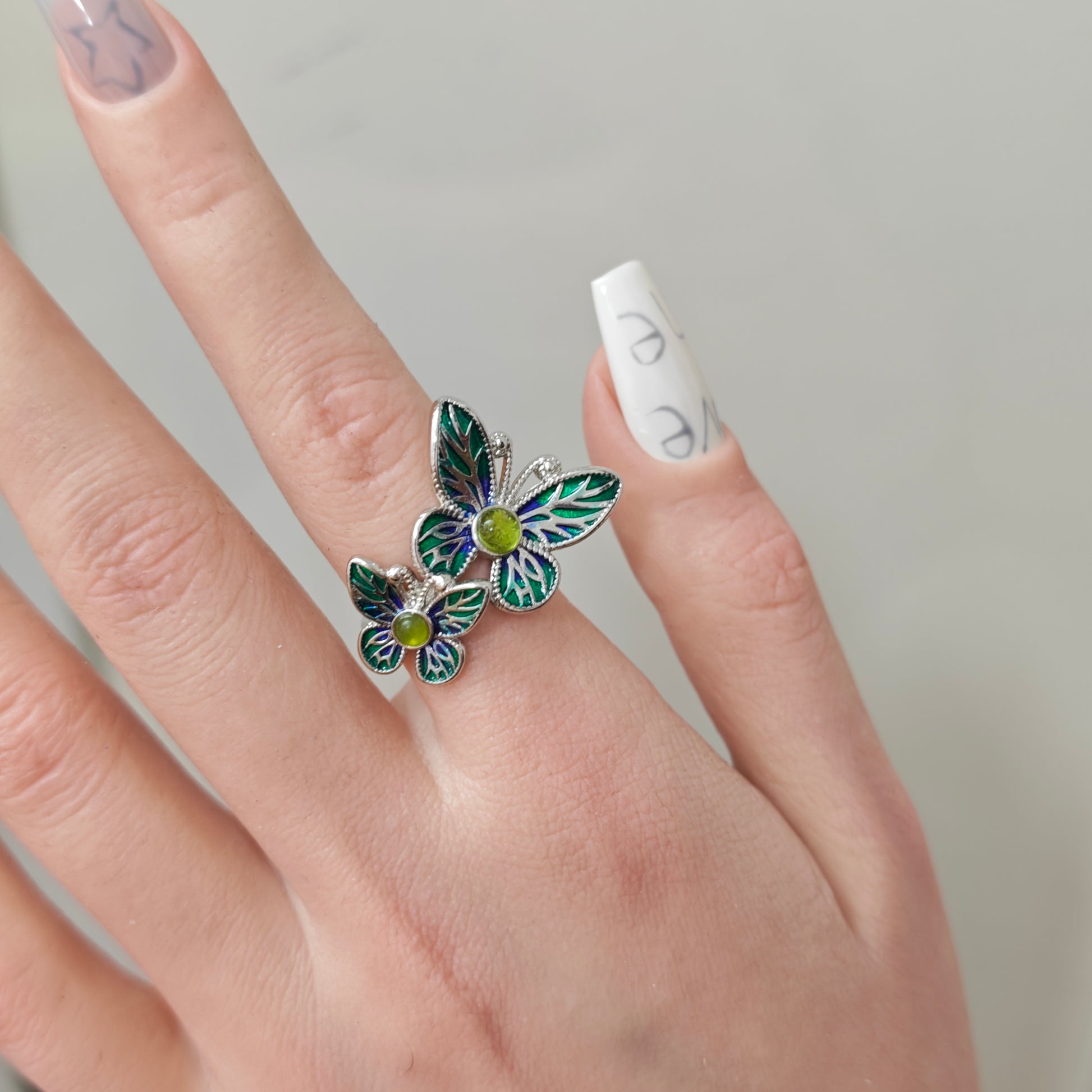 Double Butterfly Enamel Ring in open black velvet jewelry box, angled view