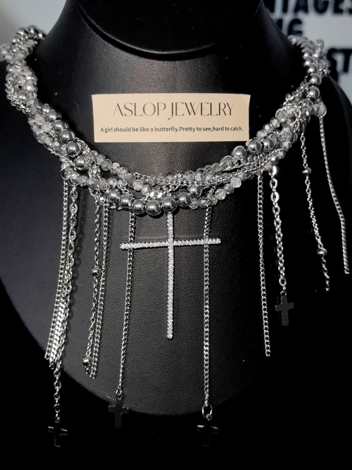 Crystal Cross Tassel Necklace in open black velvet jewelry box, angled view