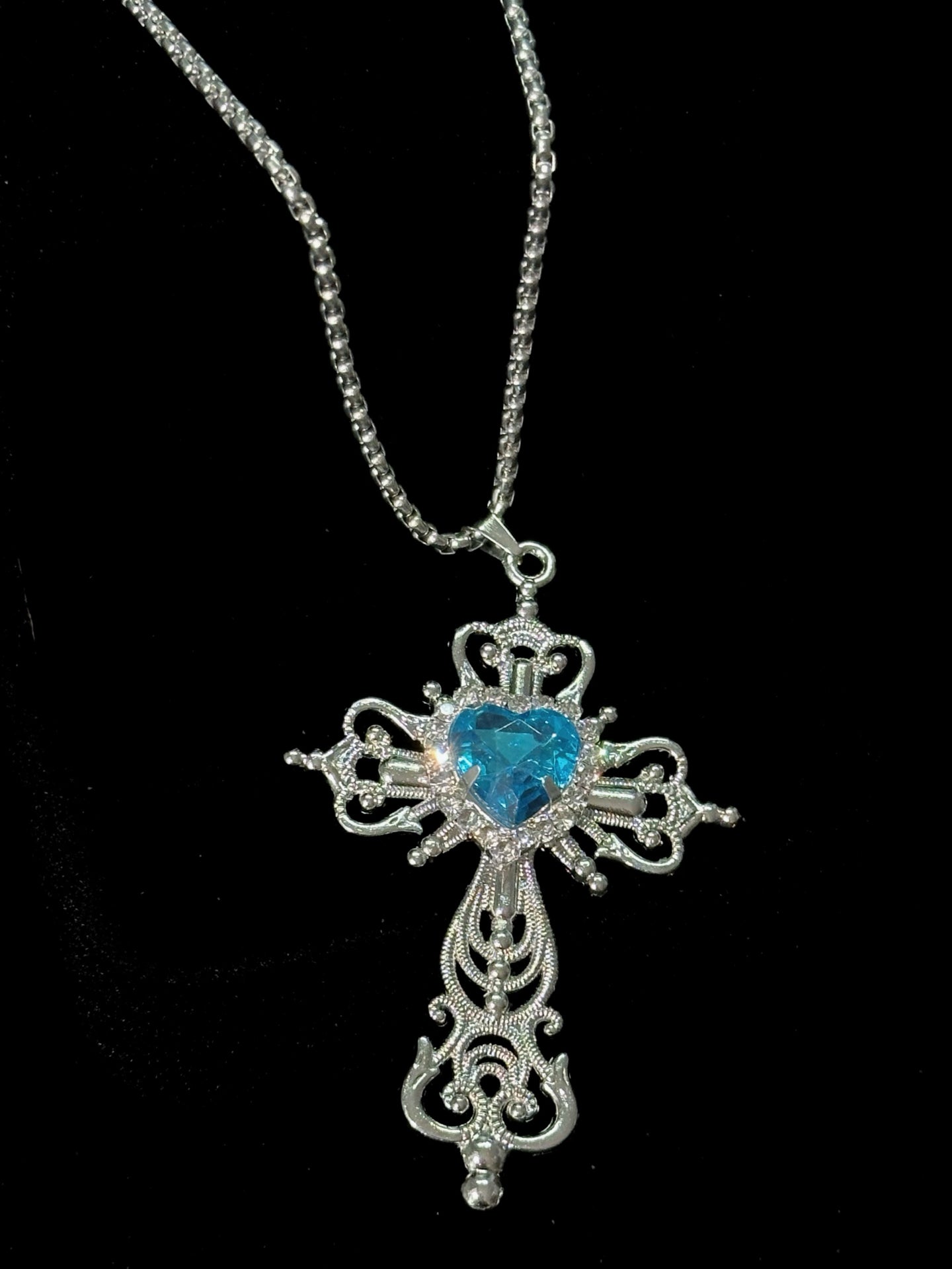 Spiked Starfish & Filigree Cross Heart Necklace Set in open black velvet jewelry box, angled view